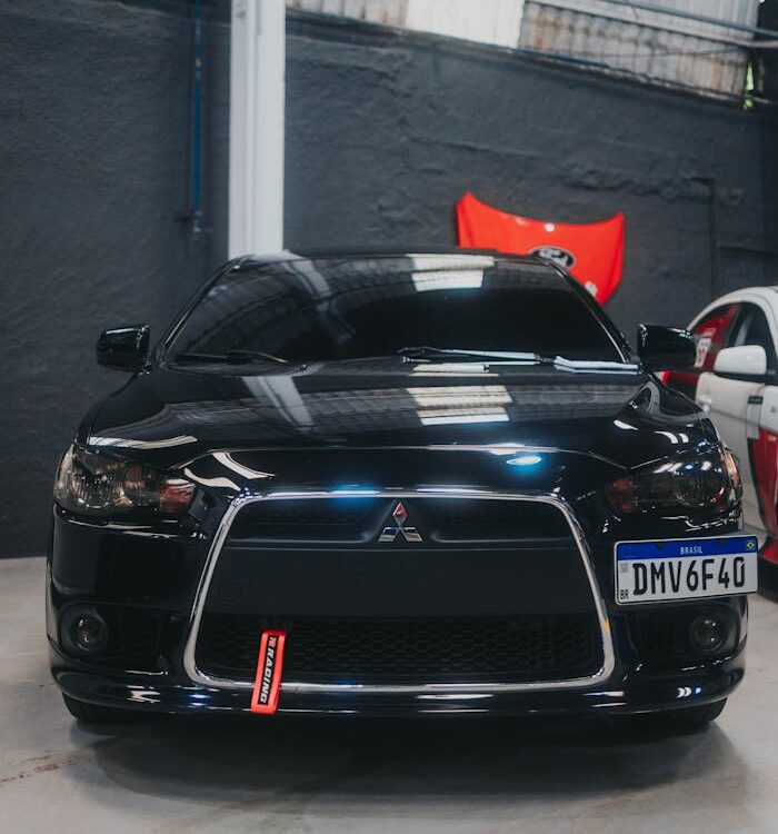 Front view of a sleek black Mitsubishi Lancer parked indoors in a garage setting.
