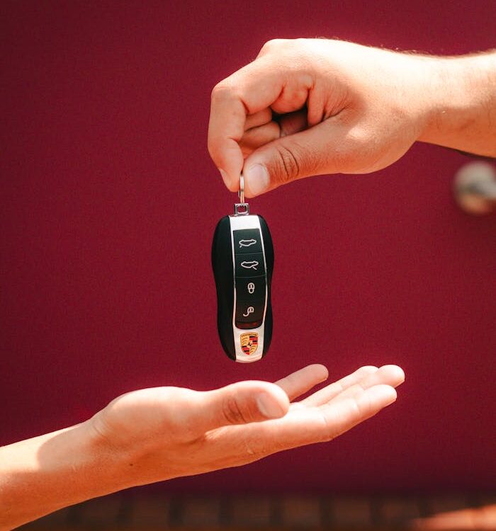 Close-up of hands exchanging a luxury car key in São Paulo, Brazil.